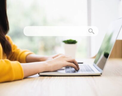Femme qui tape sur son ordinateur dans une barre de recherche
