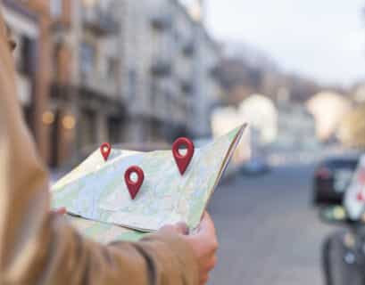 Homme regardant une carte avec des pins de type google map affichés dessus symbolisant le référencement local